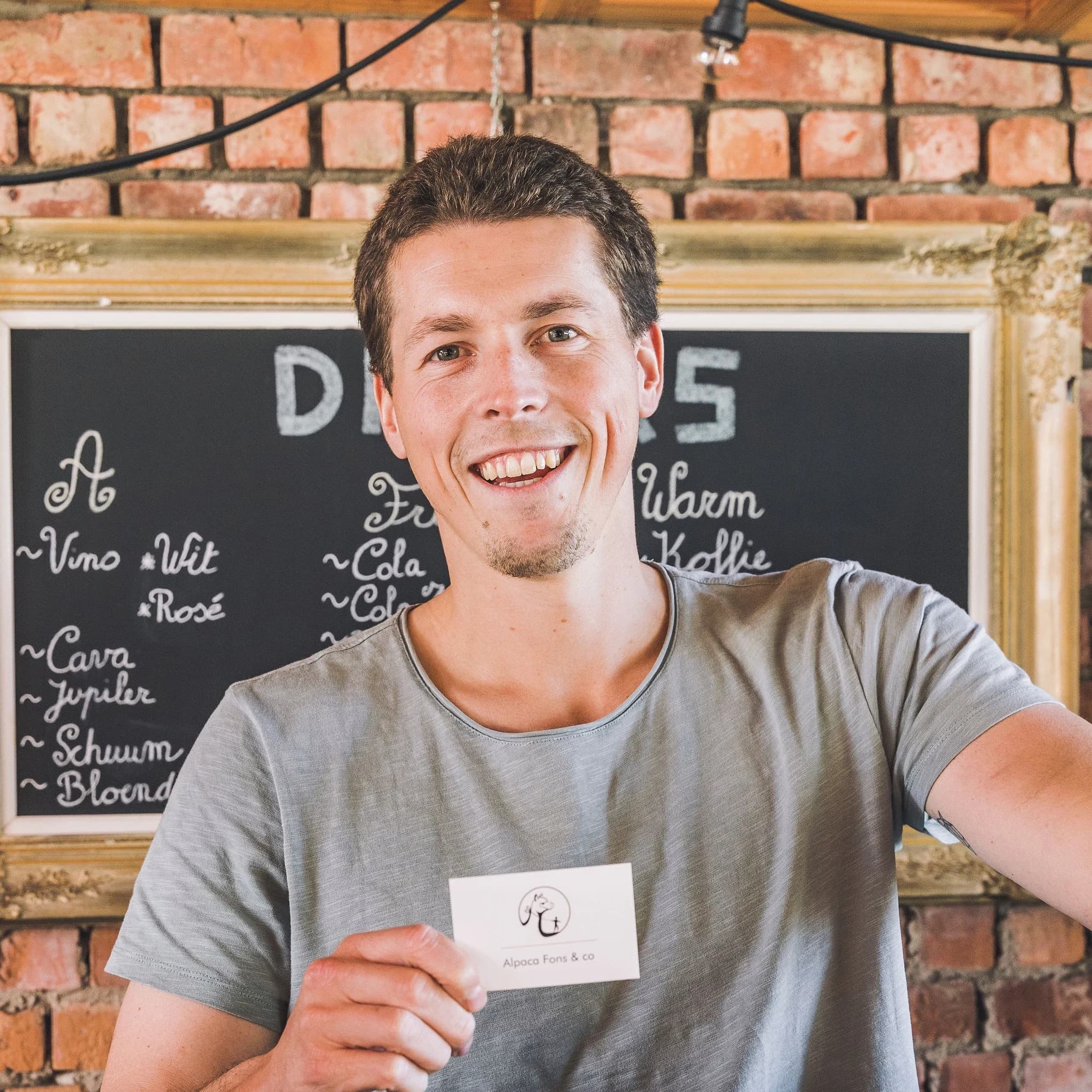Eigenaar van Fons & Co tussen de alpaca's op de weide